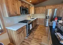 Knotty hickory galley kitchen with white quartz.