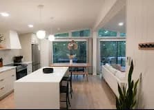 White slab kitchen with built-in banquette.