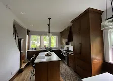 A representative finished install: white-oak shaker kitchen with island, quartz, pendants.