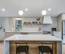 White cabinetry, quartz island, globe pendants.