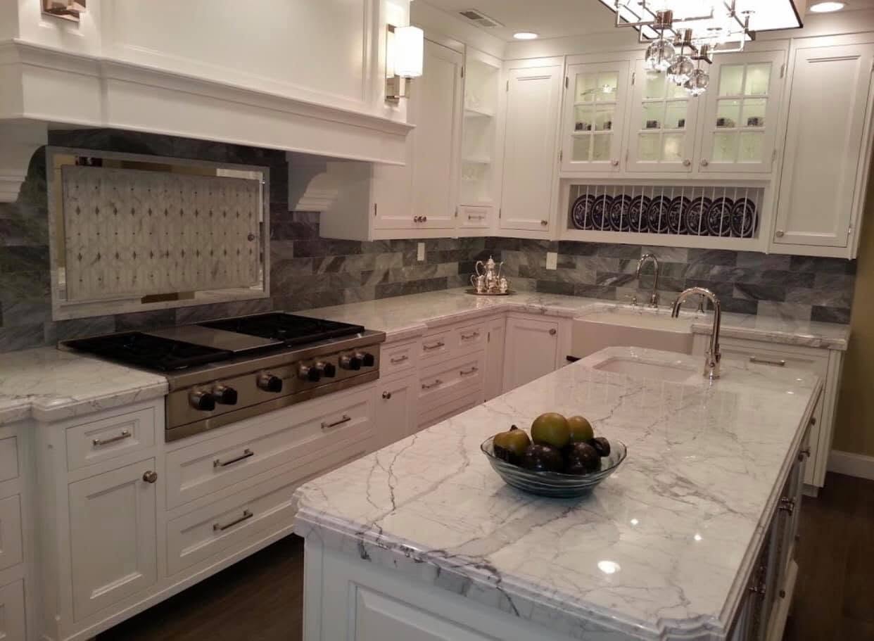A finished kitchen remodel by the 4 Squared crew: white cabinetry and a marble-top island.